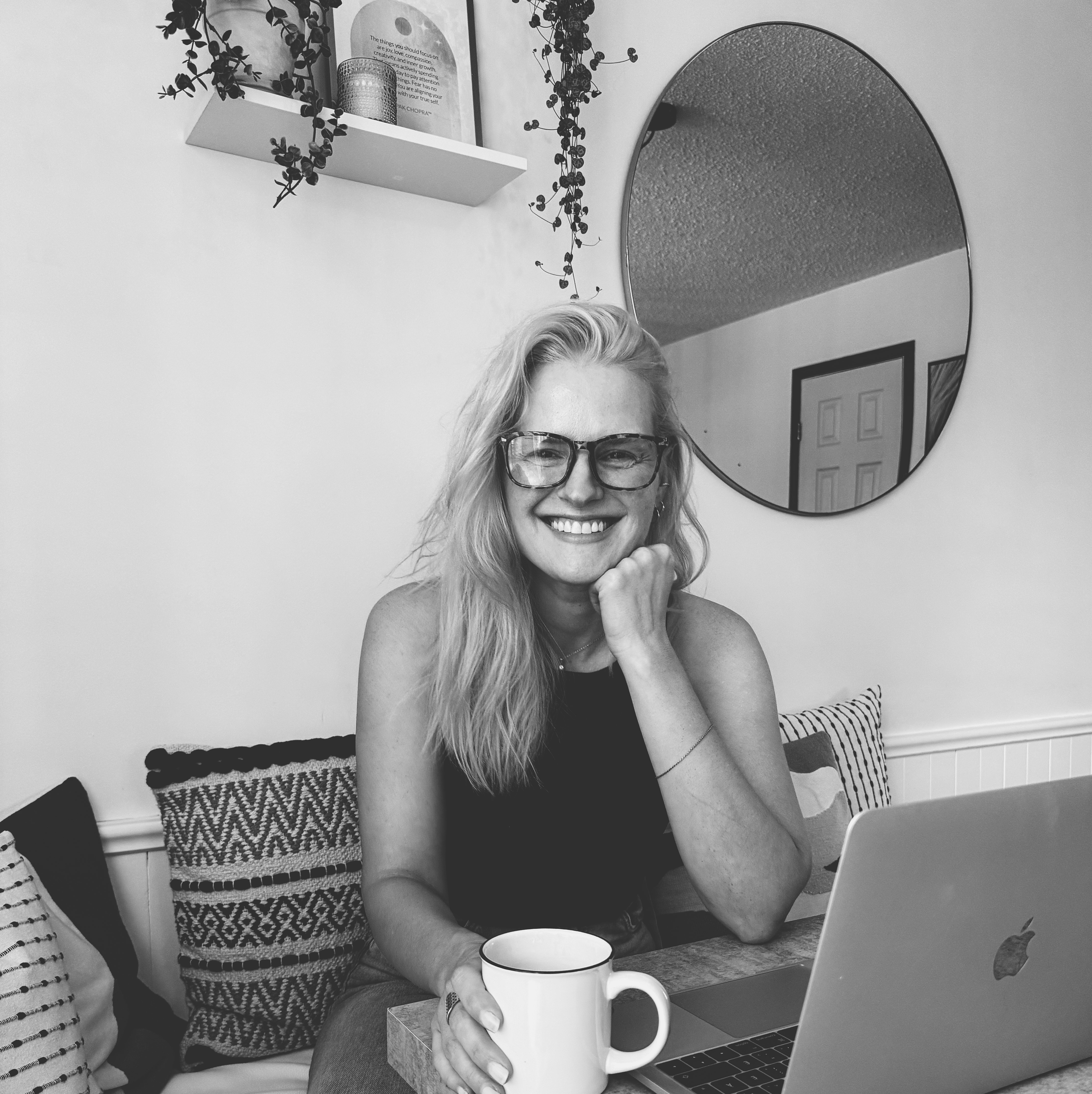 Photo noir et blanc de Christel Brochu assise à table et qui regarde la caméra en souriant